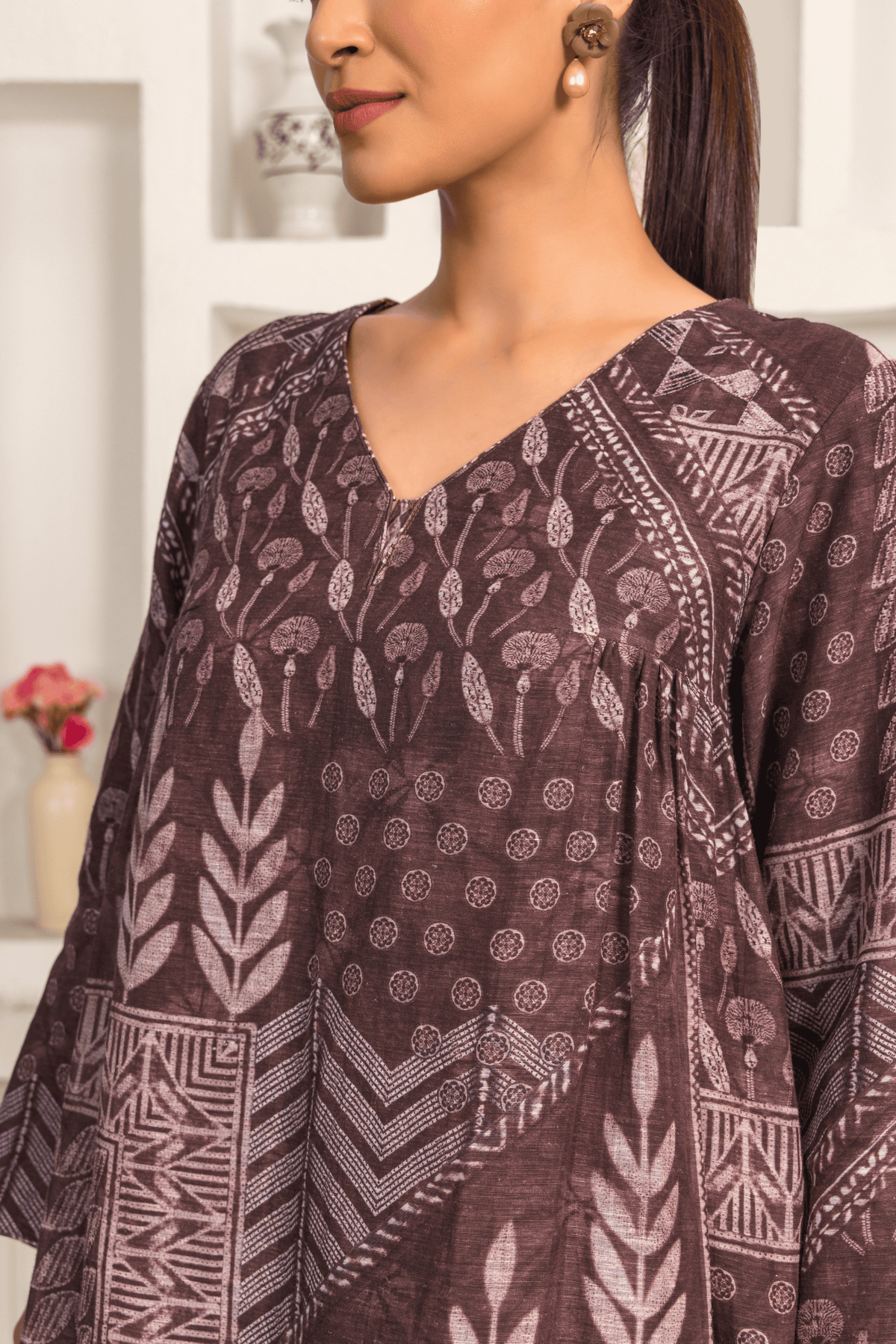 Closeup view of woman is wearing a Brown printed linen cord set with intricate white patterns, paired with matching printed pants