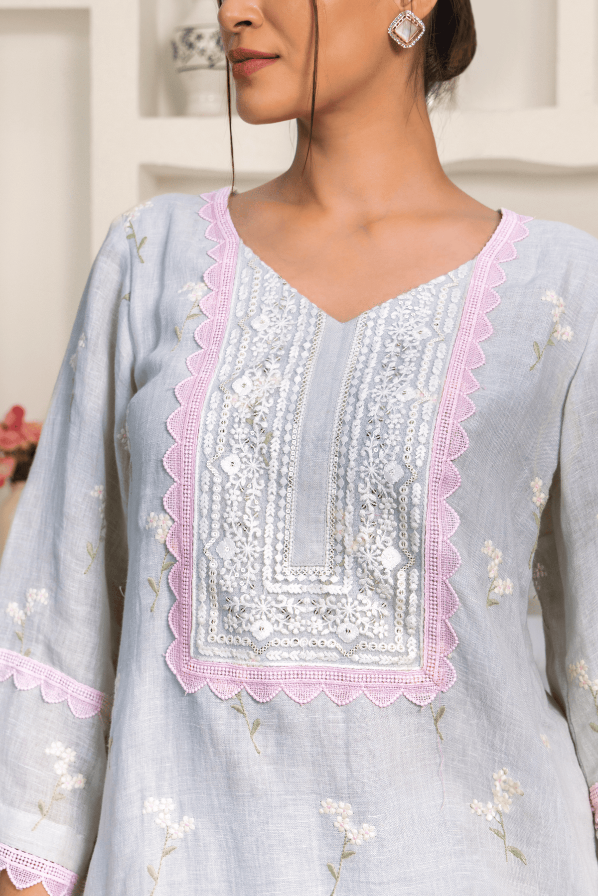 Closeup view of model wearing chic pastel blue embroidered kurta set with delicate lace detailing