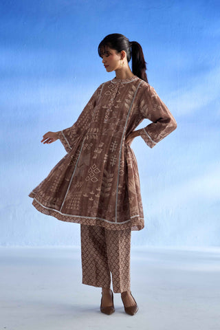 Woman wearing a brown patterned linen co-ord set against a blue sky