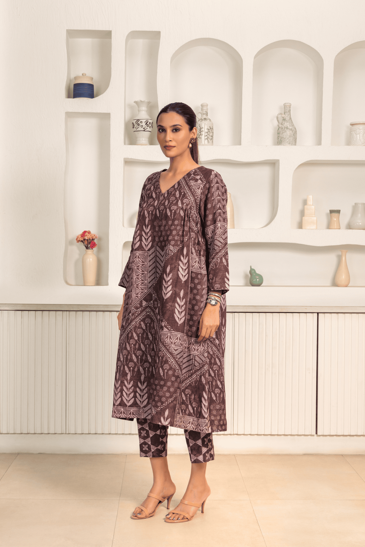 A woman is wearing a Brown printed linen cord set with intricate white patterns, paired with matching printed pants