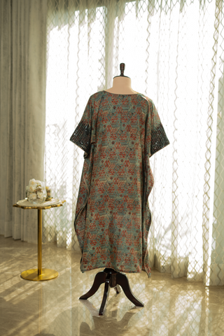 Back view of a loose-fitting, floral-patterned kaftan dress with lace sleeves, displayed on a mannequin in a softly lit room.