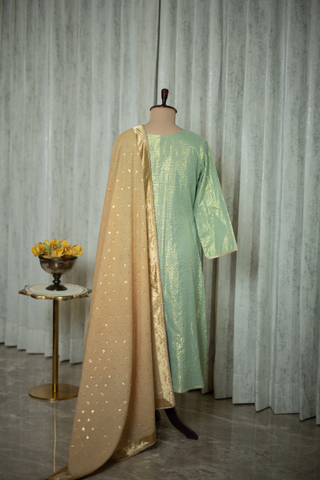 Back view of a mint green kurta with gold detailing and golden dupatta, featuring delicate tassel accents, displayed elegantly in a modern setting