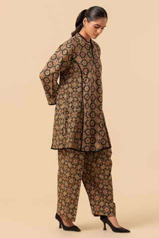 Woman wearing a patterned kurta with pants on a beige background