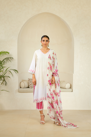 Model showcasing a white handcrafted kurta with pink embroidery and lace details, paired with striped pink pants, exuding elegance and charm