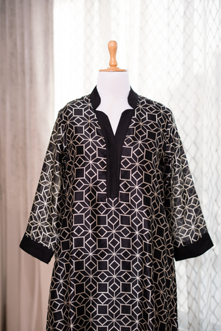 Black tunic with geometric white patterns kurta, featuring a V-neck and long sleeves, displayed on a dress form against a light backdrop.