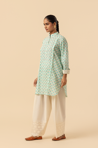 Side view of a person wearing a light teal & white cotton farshi salwar co-ord set , standing against a beige background.