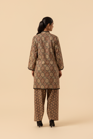Back view of a person wearing a patterned ethnic ajrakh printed farshi co-ord set featuring a long tunic and wide-legged pants, posed against a neutral background.