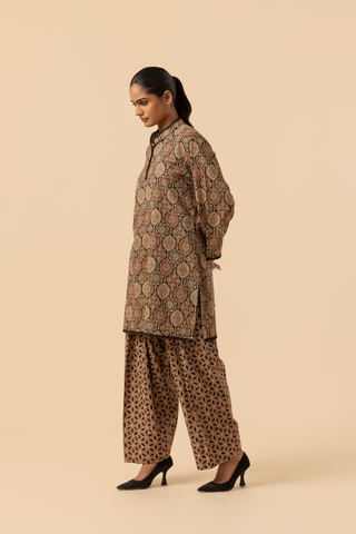 Side view of a person wearing a patterned ethnic ajrakh printed farshi co-ord set featuring a long tunic and wide-legged pants, posed against a neutral background.