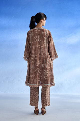 Back side of woman wearing a patterned linen co-ord set against a blue sky