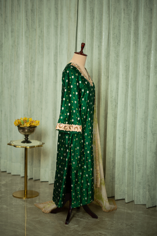 Right side view of  a green silk brocade kurta set adorned with golden embroidery, paired with a light, patterned dupatta, displayed on a mannequin.