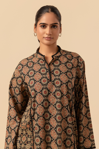 Woman wearing a ajrakh printed kurta against a beige background