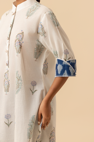 A model displays a stylish, light-colored, floral-printed kurta, set against a soft beige background.
