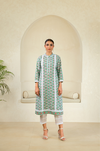 Model wearing a green handcrafted kurta with floral patterns, paired with white lace pants, showcasing a blend of traditional and contemporary ethnic wear.