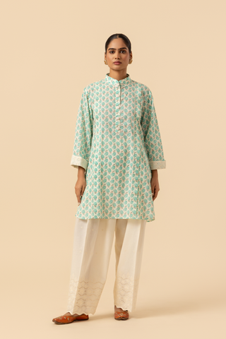 A person wearing a light teal & white cotton farshi salwar co-ord set , standing against a beige background.
