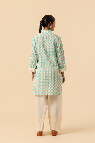 Back view of a person wearing a light teal & white cotton farshi salwar co-ord set , standing against a beige background.