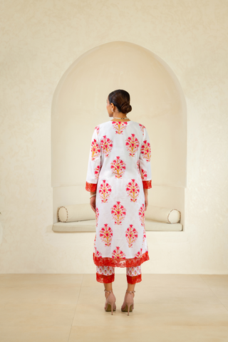 Back view of a woman wearing a handcrafted block-printed kurta set in white and red with intricate floral patterns, paired with matching pants