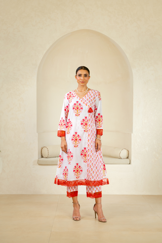 Model wearing a handcrafted block-printed kurta set in white and red with intricate floral patterns, paired with matching pants