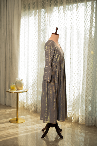 Right side view of a stylish grey anarkali kurta set, paired with a black polka-dot dupatta, displayed against a sunlit.