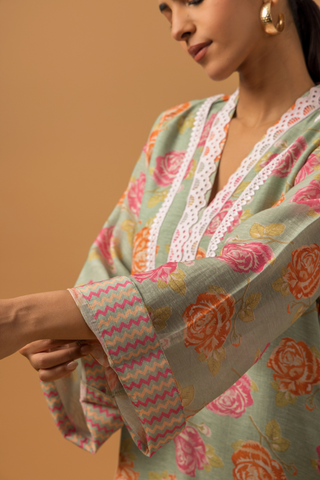 A model wearing a vibrant spring rose floral co-ord set with intricate neckline embroidery, showcasing hand sleeves.