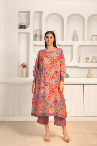 A woman is wearing a vibrant floral printed mosaic linen cord set paired with matching printed pants.