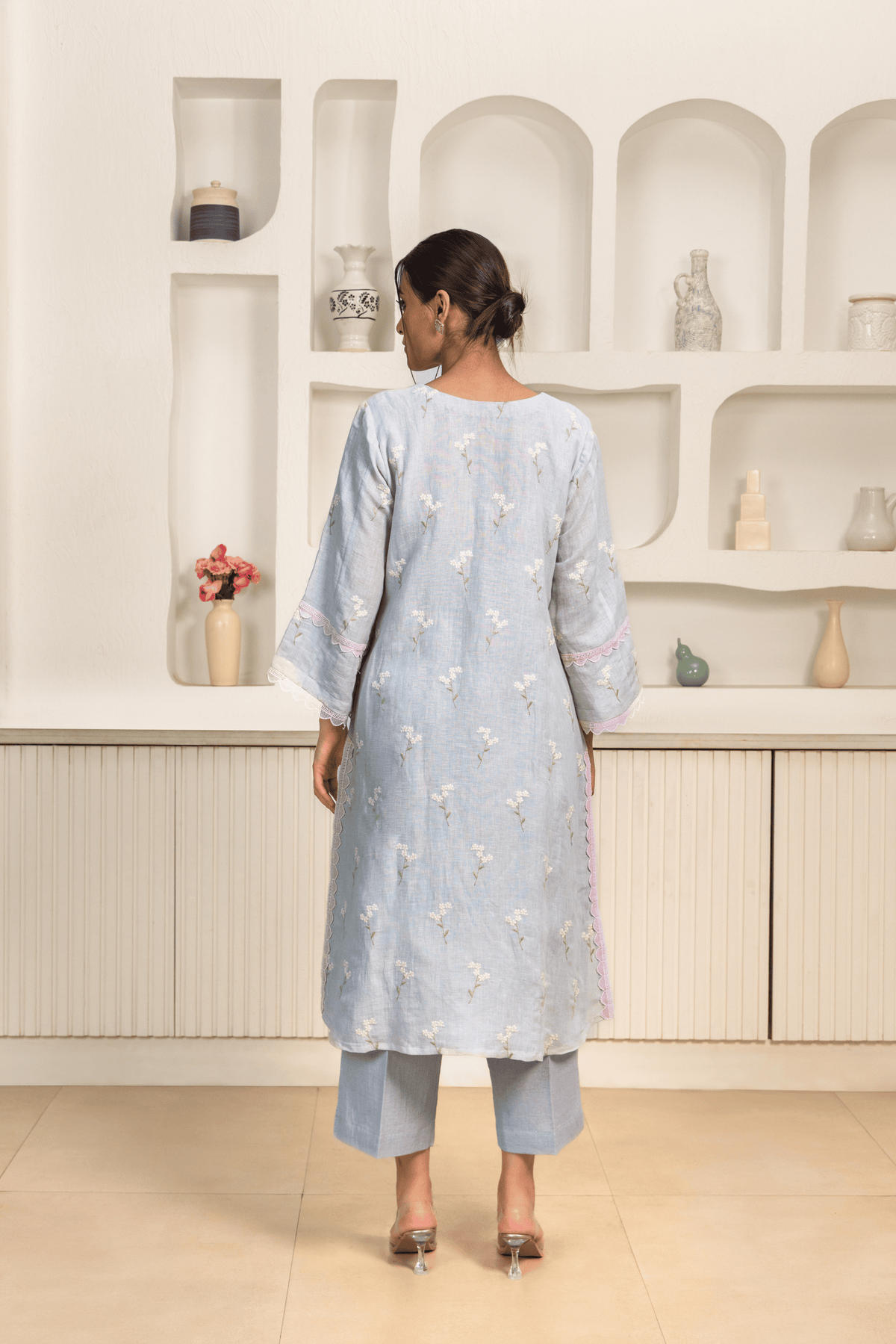 Back view of model wearing chic pastel blue embroidered kurta set with delicate lace detailing