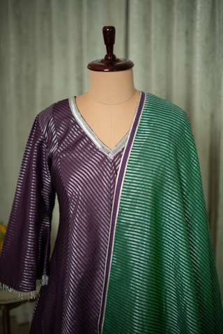 Closeup view of purple tissue chanderi kurta with a shimmering striped pattern, paired with a rich green tissue chanderi dupatta, featuring delicate silver detailing.