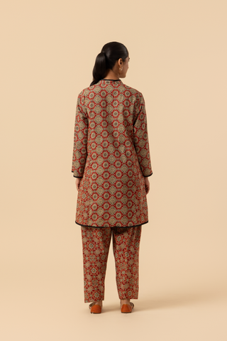 Back view of a model featuring a red patterned ajrakh print farshi salwar & kurta, set against a soft beige background.