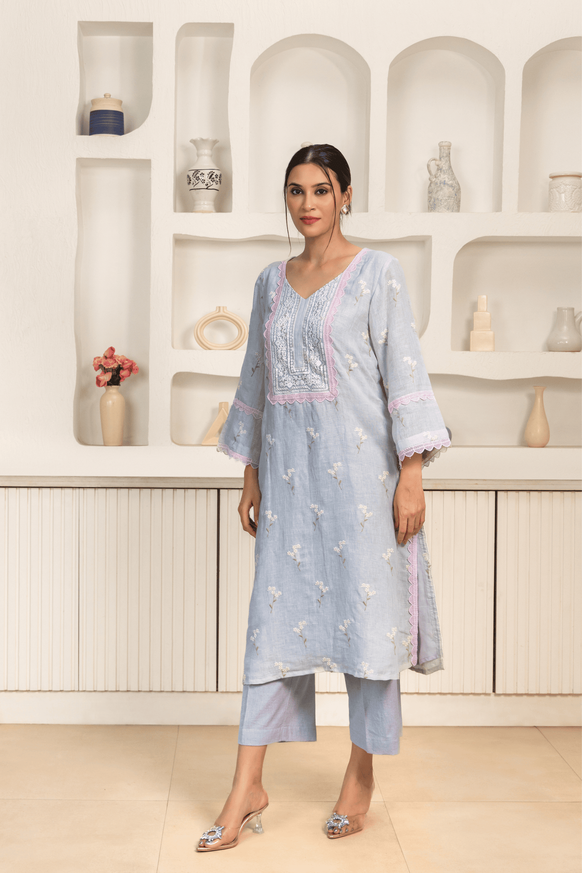 A model wearing chic pastel blue embroidered kurta set with delicate lace detailing