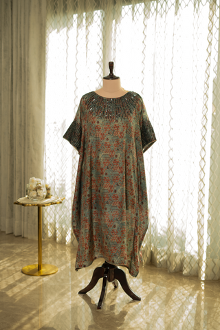 A loose-fitting, floral-patterned kaftan dress with lace sleeves, displayed on a mannequin in a softly lit room.