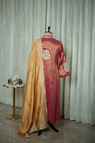 Back View of a rich maroon silk kurta with intricate embroidery and golden dupatta, exuding timeless elegance and luxury, displayed in a sophisticated setting.
