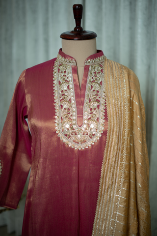 Closeup View of a rich maroon silk kurta with intricate embroidery and golden dupatta, exuding timeless elegance and luxury, displayed in a sophisticated setting.