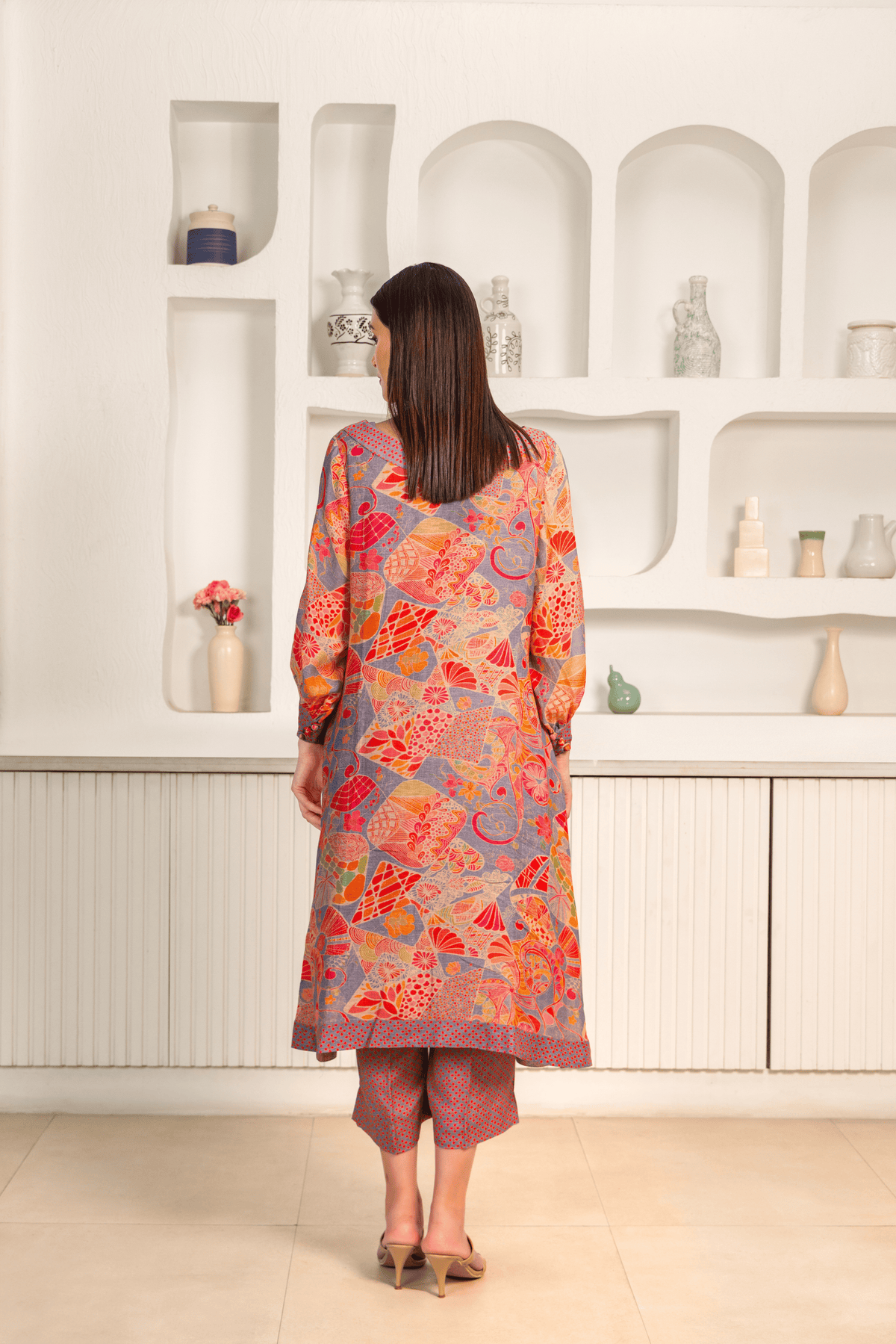 Back View of woman is wearing a vibrant floral printed mosaic linen cord set paired with matching printed pants.