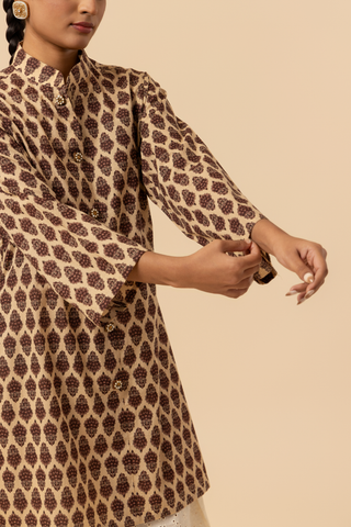 A model displays a stylish, a traditional brown patterned chikan farshi salwar co-ord set, set against a soft beige background.