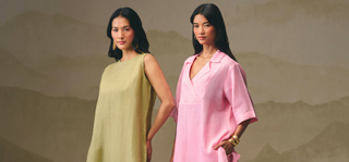 Two women modeling sleeveless linen dresses in olive green and light pink, standing against a textured beige background with a faint mountain pattern.
