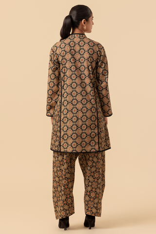 Back side of a woman wearing a ajrakh printed farshi co-ord set with pants on a beige background
